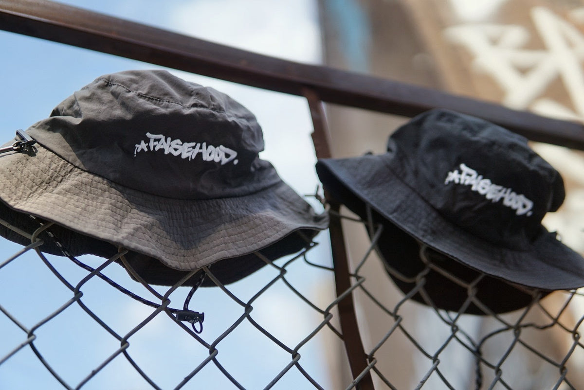 The Big TAG. Runner Waterproof Bucket Hat - FALSEHOOD.